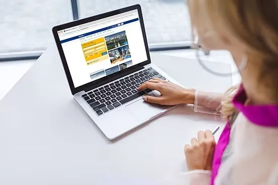 Blog 35 Woman browsing an insurance company website on a laptop.